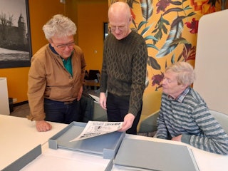 Cor de Jonge, Leo Hollestelle en Jan Hekhuis bekijken een aantal van de cartoons.