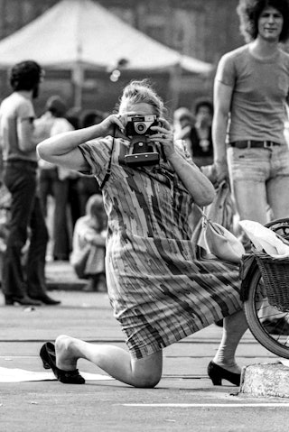 Een vrouw balanceert op een knie om een foto te maken.