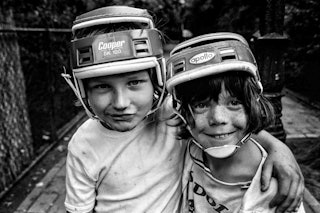 Twee jongetjes met helmen op hun hoofd poseren voor de fotograaf.