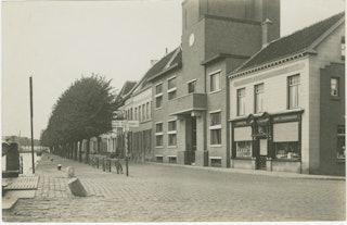 De Westkade (in zuidelijke richting) in Sas van Gent, met in het midden het gemeentehuis Sas van Gent, vóór 1935. Zeeuws Archief, Fotoarchief J. Torbijn, Goes, nr SAS-12.