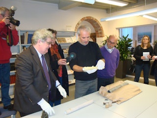 Links wethouder Piet Polderman en rechts gemeentearchivaris Ad Tramper. Ad Tramper houdt een koker vast die is gevonden bij de restauratie van het standbeeld van Michiel de Ruyter.