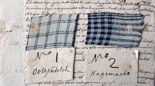 Op een met inkt geschreven brief liggen twee stukjes stof, beide blauw gestreept. Onder het stukje textiel ligt een klein briefje met de tekst No 1 Oostindisch, onder het tweede No 2 nagemaakt.