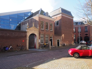 Gevel van de gebouwen van het Zeeuws Archief aan het Hofplein in Middelburg, met de zandstenen toegangspoort naar de ingang.