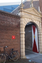 Een oude poort van geelgeverfde steen geeft toegang tot de ingang van het Zeeuws Archief.