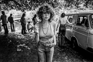 Een vrouw met een sigaret in haar hand staart in de verte.