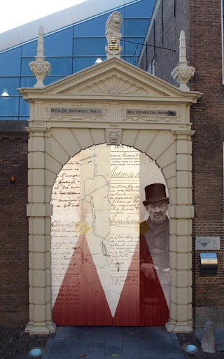De ruimte onder een oude poort is gevuld met een montage; een collage van de kleuren van Middelburg, archiefstukken en een foto.